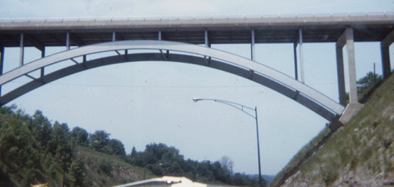 Metal arch below deck bridge